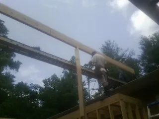 Carpenter setting a ridge beam over a new addition frame — Ice Dam Removal by Roofing Brothers in Lake Dallas