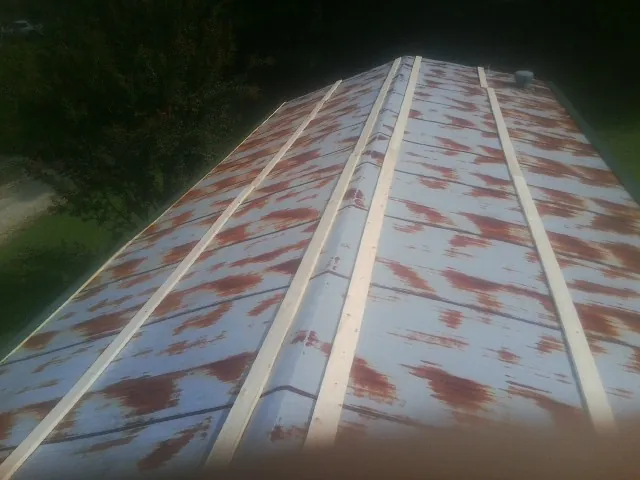 Rusted metal roof panels with new wood purlins before replacement — Storm Damage Roof Repair in Lake Dallas by Roofing Brothers