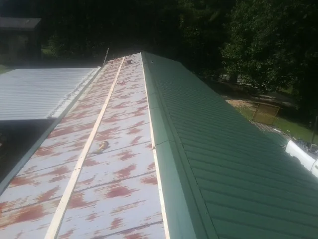 Old rusted panels beside newly installed green metal roofing — Wind Damage Roof Repair by Roofing Brothers in Lake Dallas
