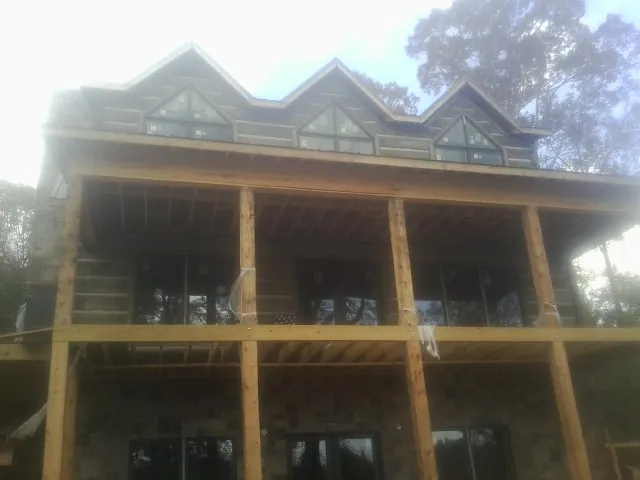 Dormers and porch framing on a large log home under construction — Roof Coating work by our crew in Lake Dallas