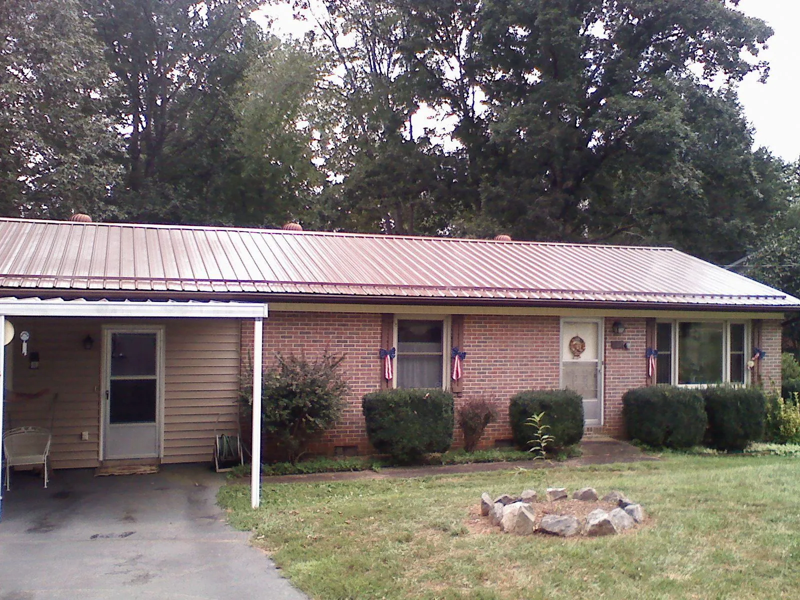 Bronze metal roof and carport on a brick ranch home — Roof Repair work by our crew in Lake Dallas